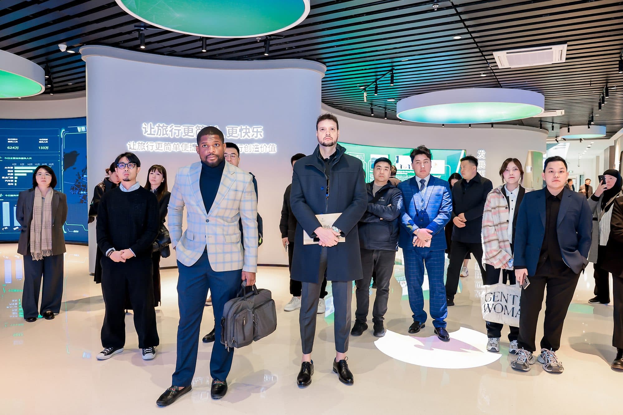 Patrick Che and Jay Dastin with delegates in the Tongcheng Travel exhibition hall