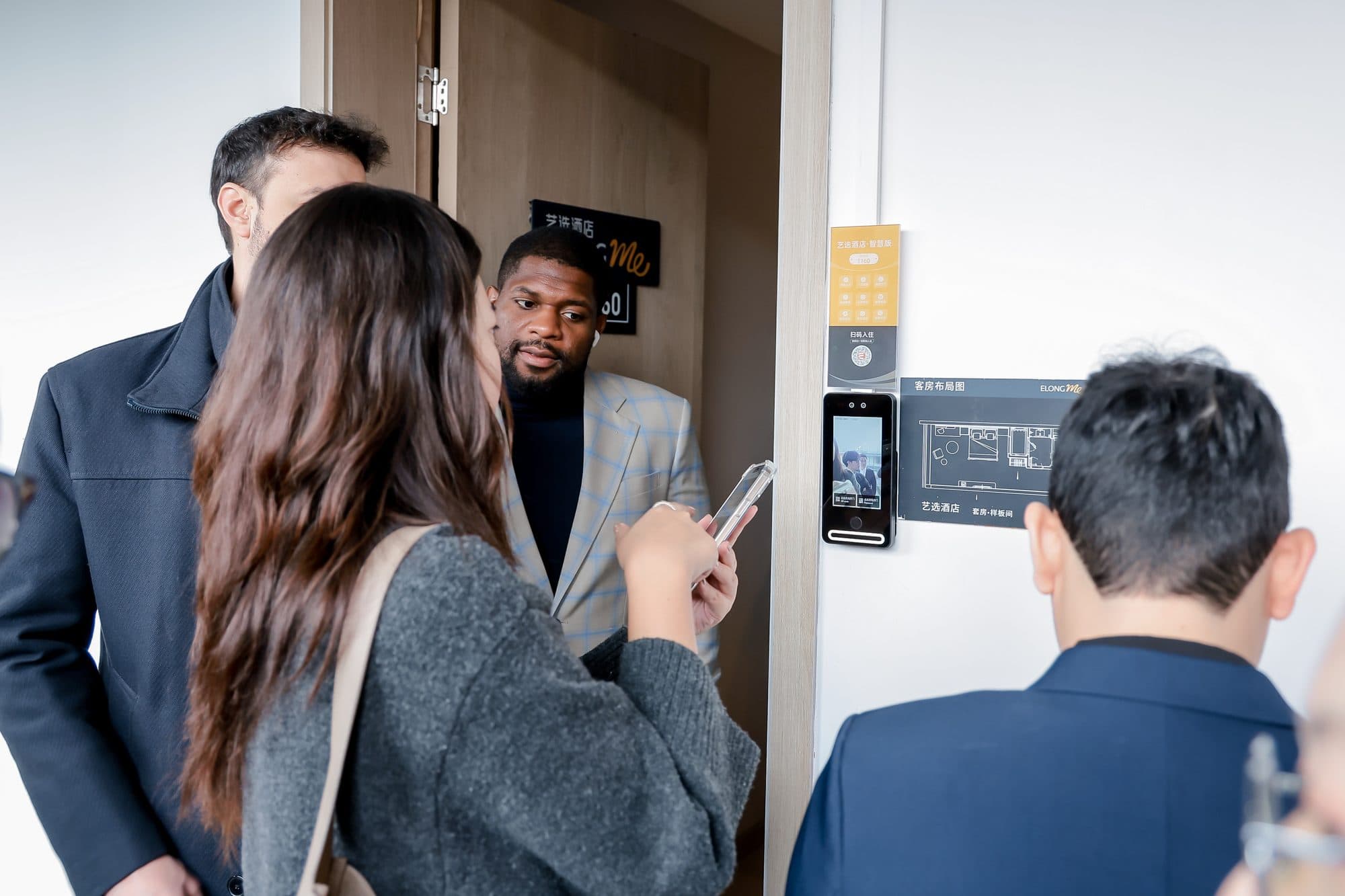 Face recognition entry panel beside a hotel room door